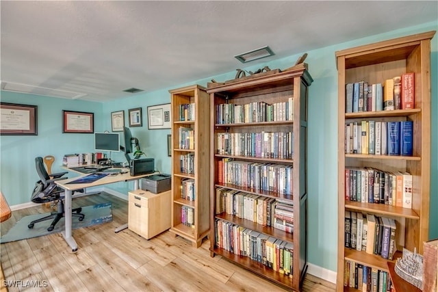 home office with light hardwood / wood-style floors