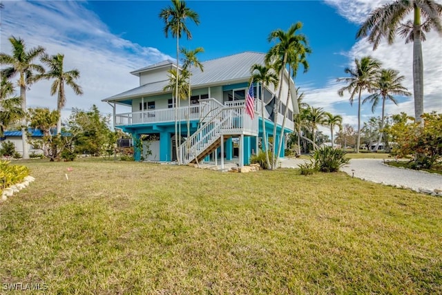 back of property featuring covered porch and a yard