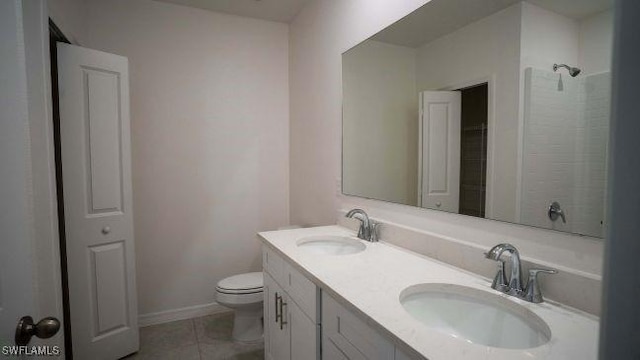 bathroom with toilet, vanity, and tile patterned flooring