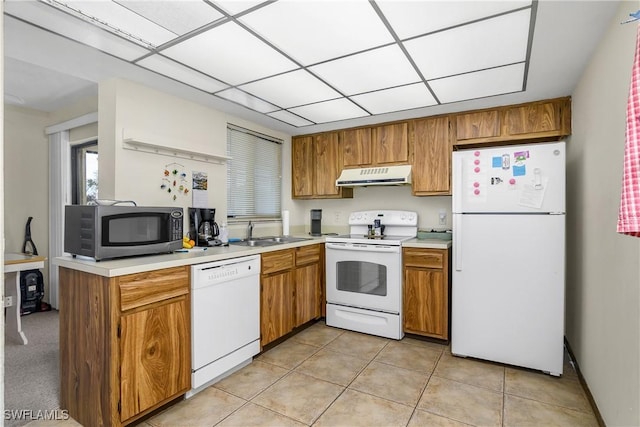 kitchen featuring white appliances, sink, and light tile patterned floors