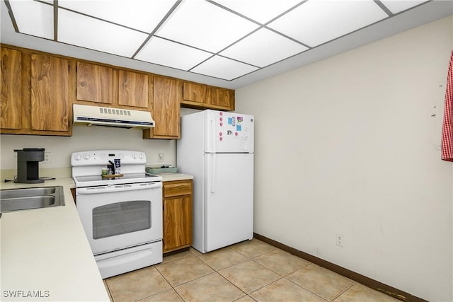 kitchen featuring sink, white appliances, and light tile patterned flooring