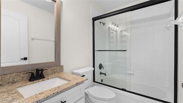 full bathroom with toilet, vanity, and shower / bath combination with glass door