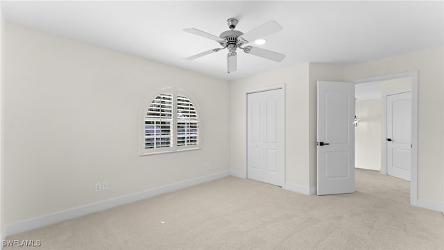 unfurnished bedroom featuring ceiling fan, a closet, and light colored carpet