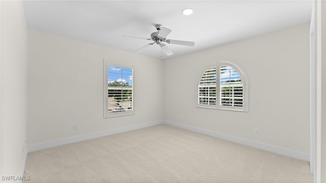 carpeted spare room with ceiling fan