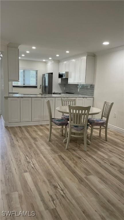 dining area with sink and light wood-type flooring