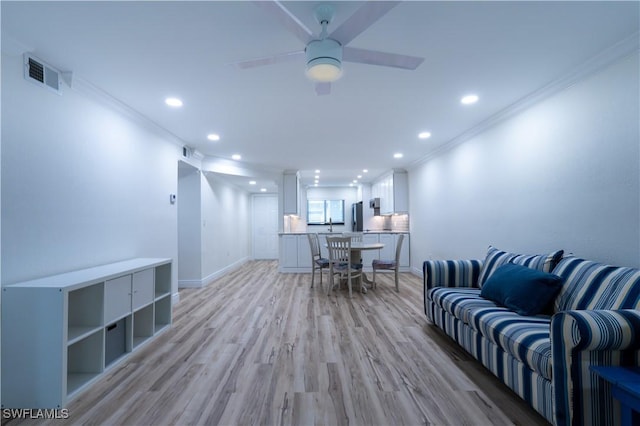 office space featuring crown molding, ceiling fan, and light hardwood / wood-style flooring