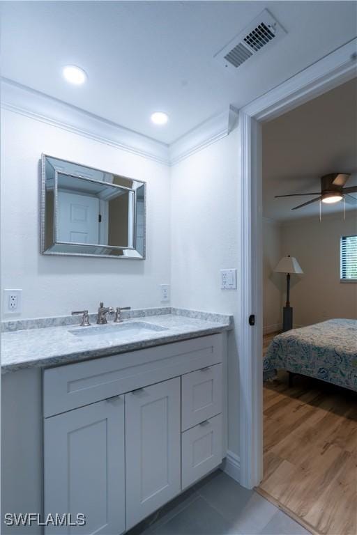 bathroom featuring hardwood / wood-style flooring, ceiling fan, vanity, and crown molding