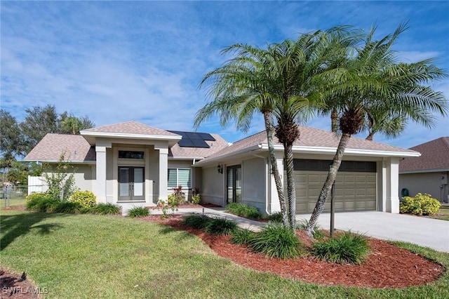 view of front of home featuring a garage, a front yard, and solar panels