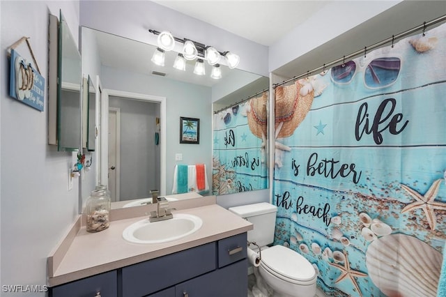 bathroom featuring toilet, vanity, and walk in shower