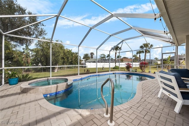 view of swimming pool with glass enclosure, a patio area, and an in ground hot tub