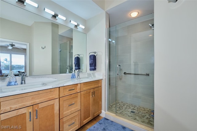 bathroom featuring ceiling fan, a shower with shower door, and vanity