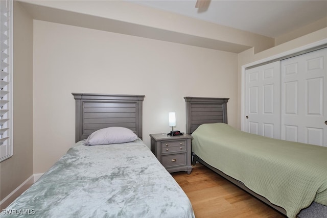 bedroom with light wood-type flooring, a closet, and ceiling fan