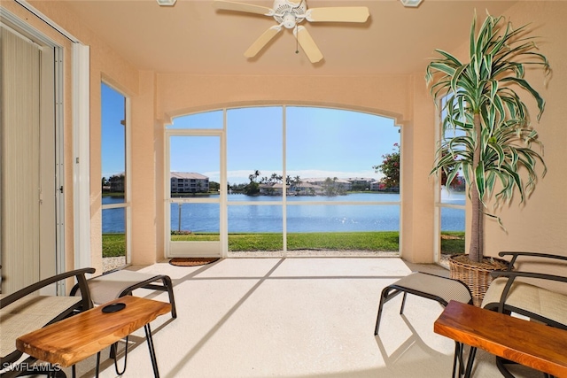 sunroom featuring a water view, a healthy amount of sunlight, and ceiling fan