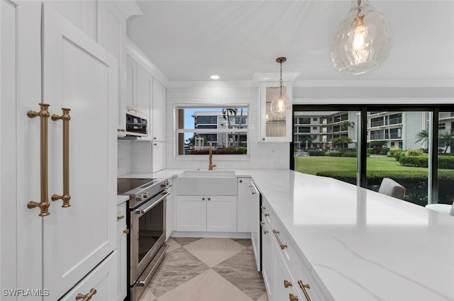 kitchen with appliances with stainless steel finishes, sink, light stone counters, and white cabinetry