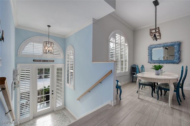 dining area with an inviting chandelier, a wealth of natural light, and ornamental molding