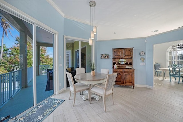 dining room with crown molding and light hardwood / wood-style flooring