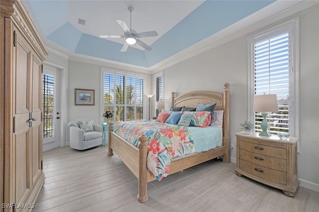 bedroom featuring access to outside, ornamental molding, a tray ceiling, ceiling fan, and light hardwood / wood-style floors