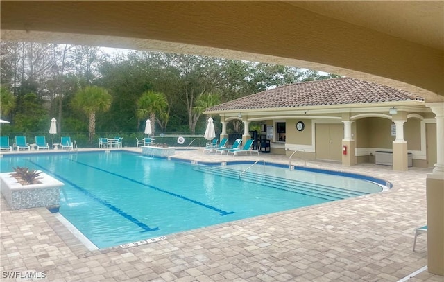 pool with a patio area and fence