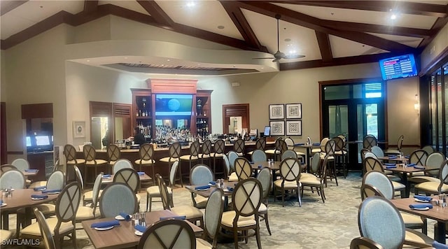 carpeted dining room featuring high vaulted ceiling and beamed ceiling