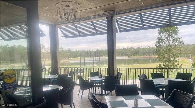 dining room featuring a water view, a wealth of natural light, and a notable chandelier