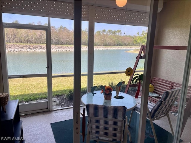 sunroom / solarium with a water view and a healthy amount of sunlight