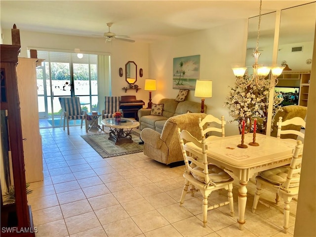 dining space featuring light tile patterned floors, ceiling fan with notable chandelier, and visible vents