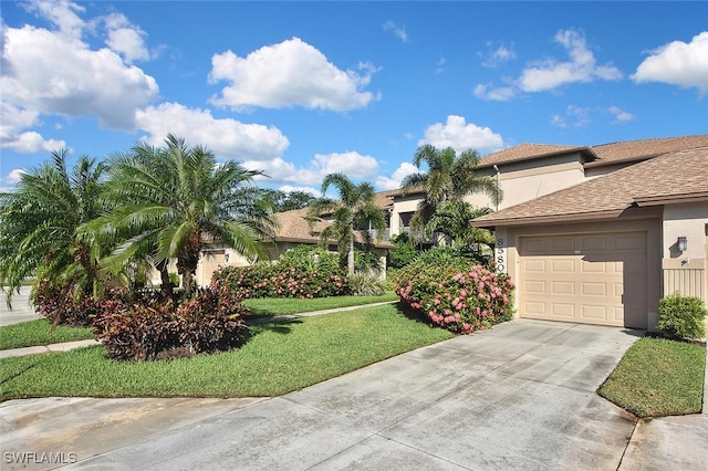 8580 Cedar Hammock Cir Unit 714, Naples, FL 34112 - view of front facade featuring stucco siding, concrete driveway, a garage, and a front lawn