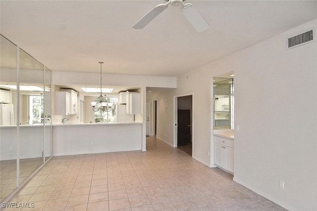 8580 Cedar Hammock Cir Unit 714, Naples, FL 34112 - kitchen with freestanding refrigerator, light countertops, a chandelier, white cabinetry, and ceiling fan