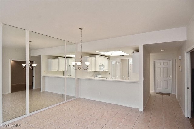 8580 Cedar Hammock Cir Unit 714, Naples, FL 34112 - kitchen with a chandelier, light tile patterned floors, range, and white microwave