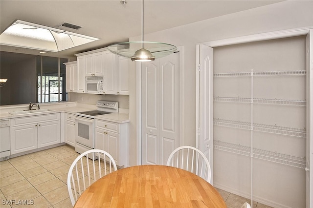 8580 Cedar Hammock Cir Unit 714, Naples, FL 34112 - kitchen featuring white appliances, light tile patterned flooring, white cabinetry, light countertops, and decorative light fixtures