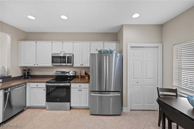 kitchen with light tile patterned flooring, stainless steel appliances, and white cabinets