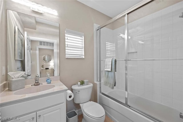 full bathroom with enclosed tub / shower combo, toilet, and vanity