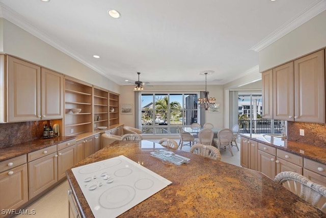 kitchen featuring decorative light fixtures, a breakfast bar area, dark stone counters, and white electric stovetop