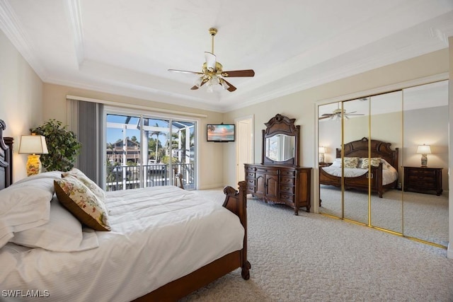 carpeted bedroom featuring crown molding, access to outside, a raised ceiling, and ceiling fan