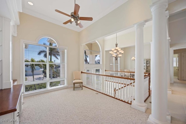 sitting room with ornate columns, crown molding, carpet floors, and ceiling fan with notable chandelier