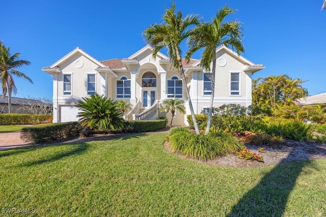 mediterranean / spanish-style home featuring a garage and a front yard