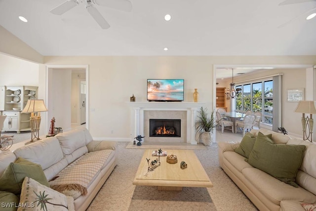 living room featuring lofted ceiling and ceiling fan with notable chandelier