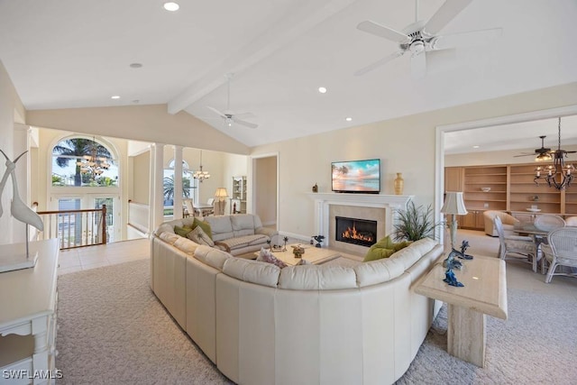 carpeted living room with ornate columns, ceiling fan with notable chandelier, and vaulted ceiling with beams