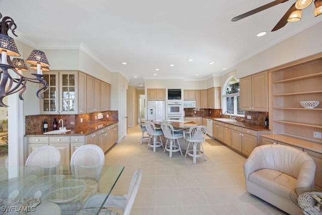 kitchen with ornamental molding, sink, light tile patterned flooring, and white appliances