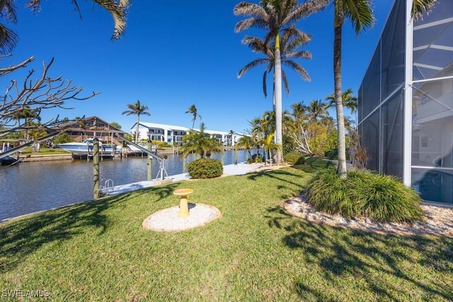 view of yard featuring a water view, a lanai, and a boat dock