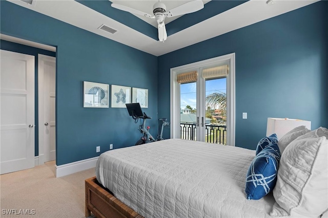 carpeted bedroom featuring a tray ceiling, access to outside, and ceiling fan