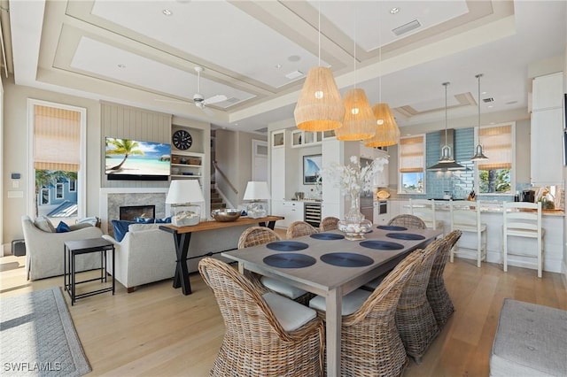 dining area featuring a tray ceiling, light hardwood / wood-style floors, and ceiling fan