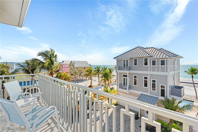 balcony featuring a water view and a view of the beach