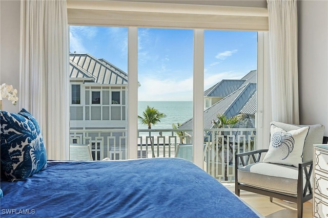 bedroom with a water view and hardwood / wood-style floors