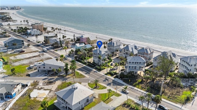 birds eye view of property with a water view and a view of the beach