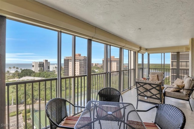 sunroom featuring a water view