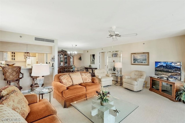 living room featuring light carpet and ceiling fan with notable chandelier