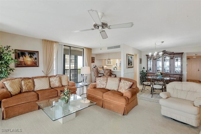 carpeted living room featuring ceiling fan with notable chandelier