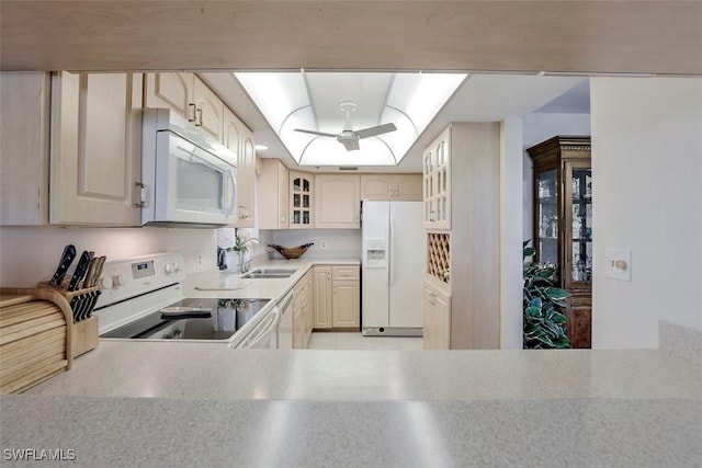 kitchen featuring sink, white appliances, and a raised ceiling