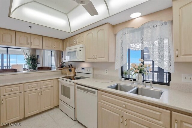 kitchen featuring sink, light tile patterned floors, and white appliances